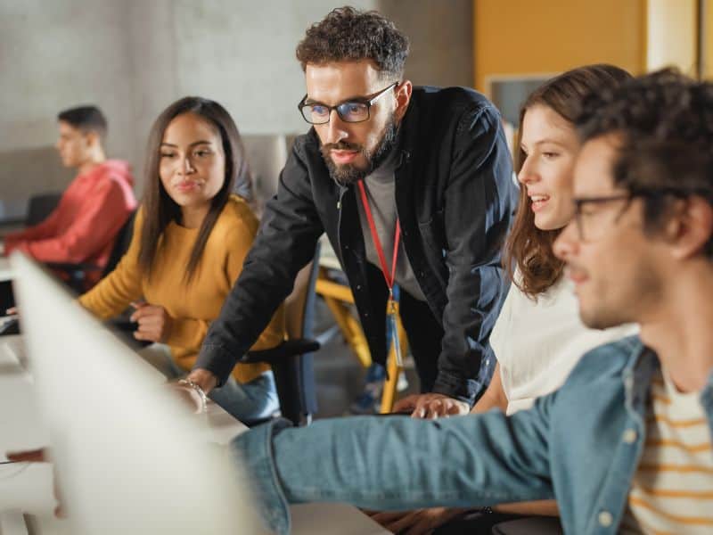 Lecturer works with a group of students