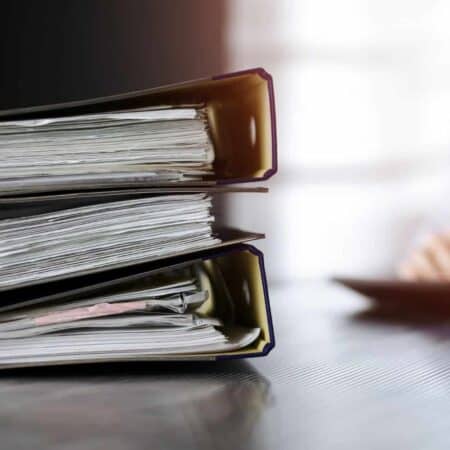 Three large folders with paperwork inside.