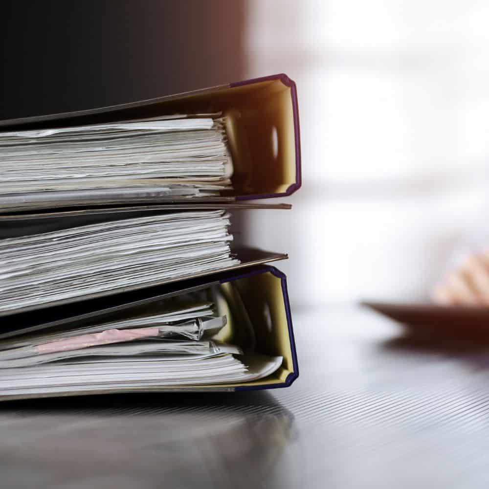 Three large folders with paperwork inside.