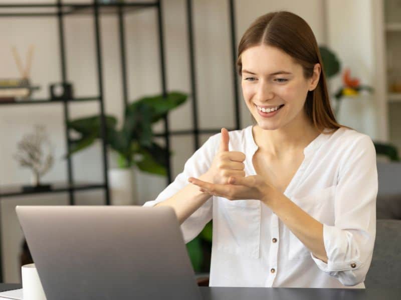 Women looking at laptop and communicating in sign language