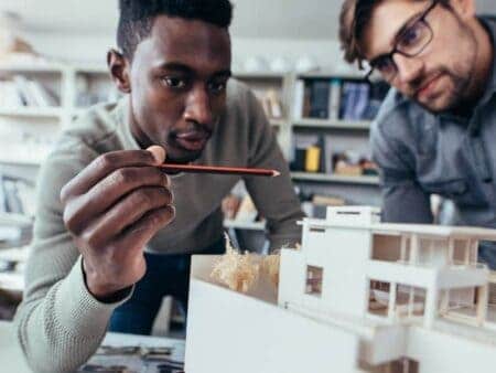 Two design engineers look at construction model