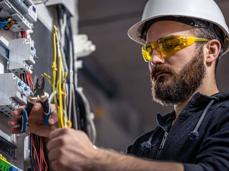 Male electrician is working on a switchboard