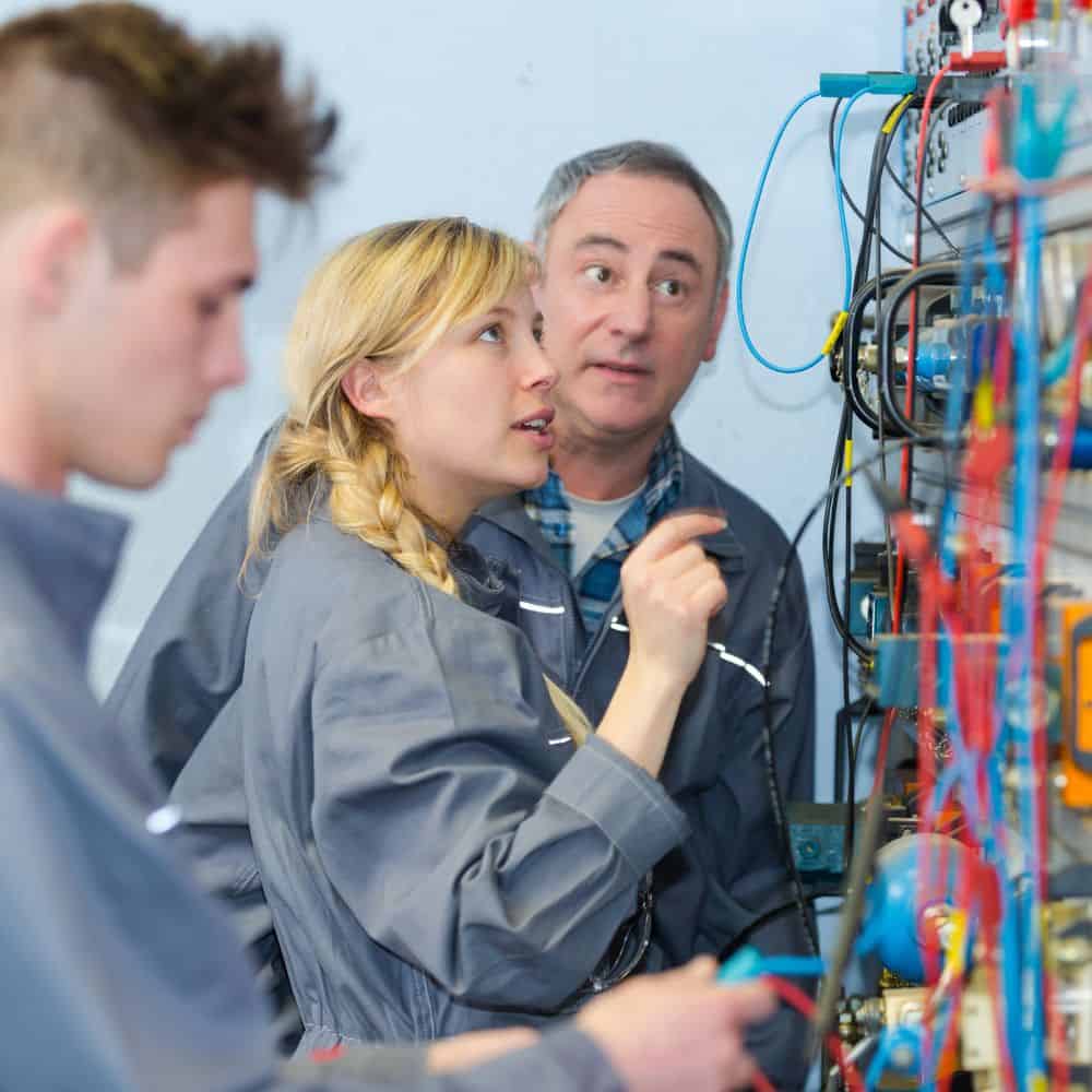 Woman and man examine electrical switch board