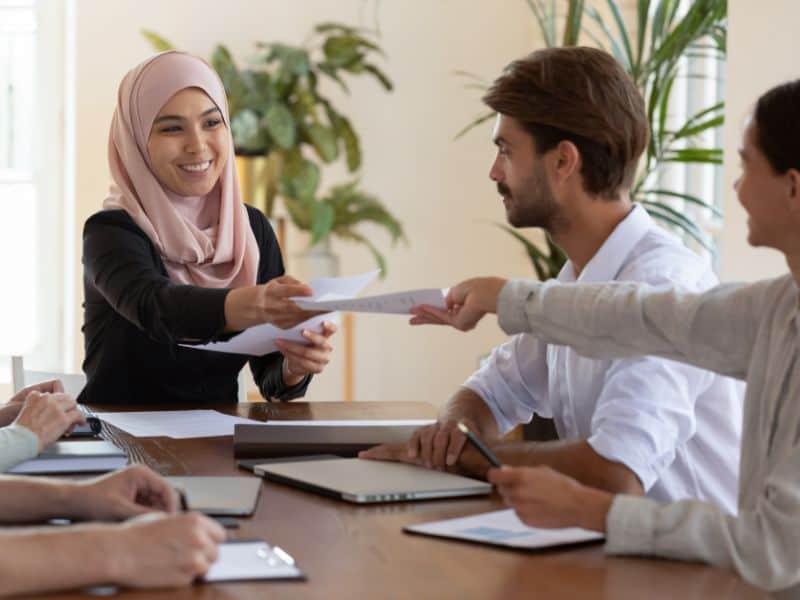 A woman wearing a hijab is smiling and taking part in a training session