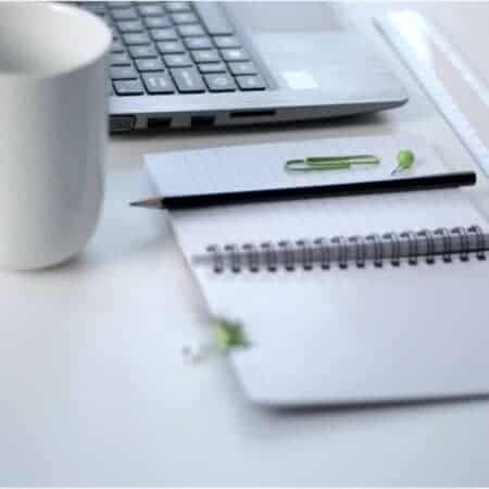 Mug, laptop and notepad with pencil