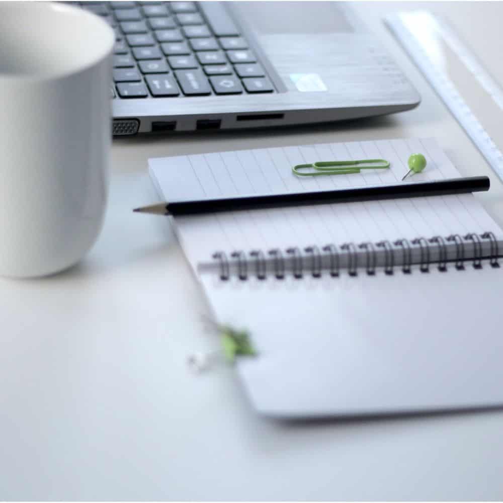Mug, laptop and notepad with pencil