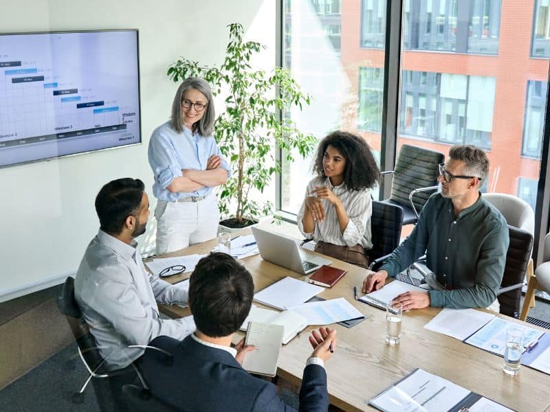 Boardroom meeting with woman presenting to group