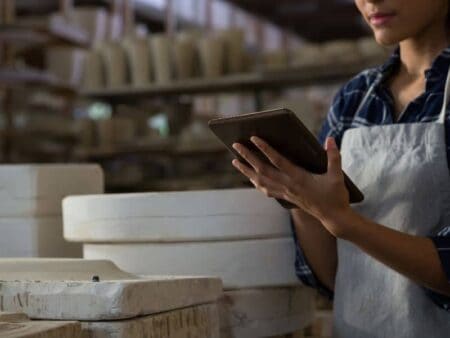 Woman in apron using a digital tablet device