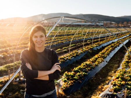 Woman smiling in front of an agricultural field