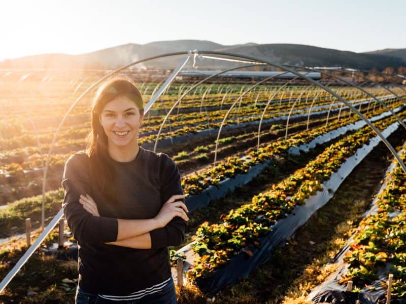 Woman smiling in front of an agricultural field