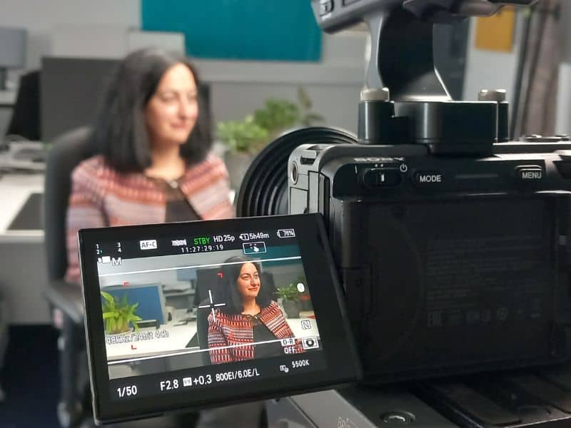 Image of woman being filmed in an office