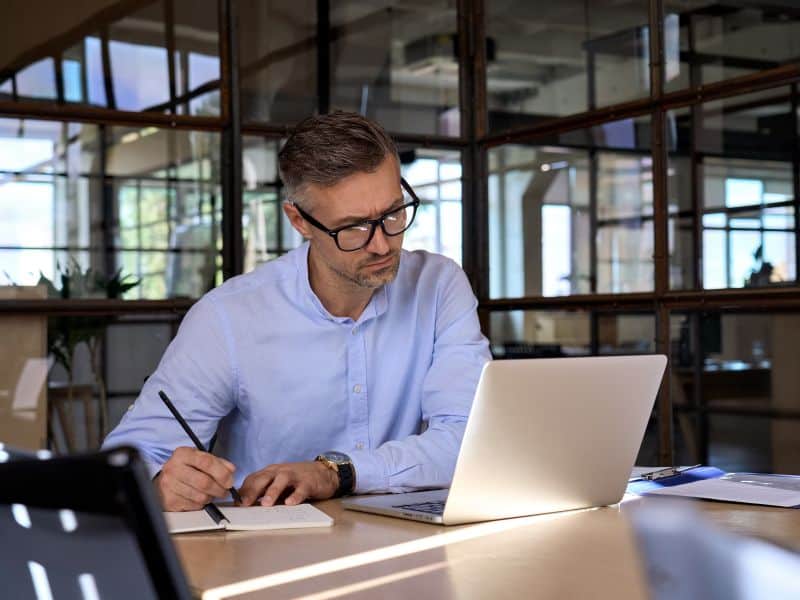 Sustainability analyst sat at a desk looking at a laptop