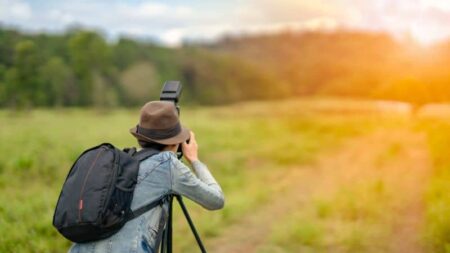 Image of person taking a photograph in a field