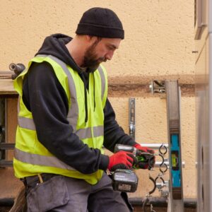 Man in high-vis jacket installing a heat pump