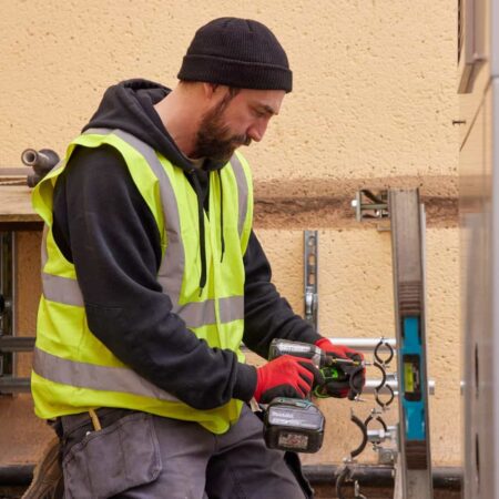 Man in high-vis jacket installing a heat pump