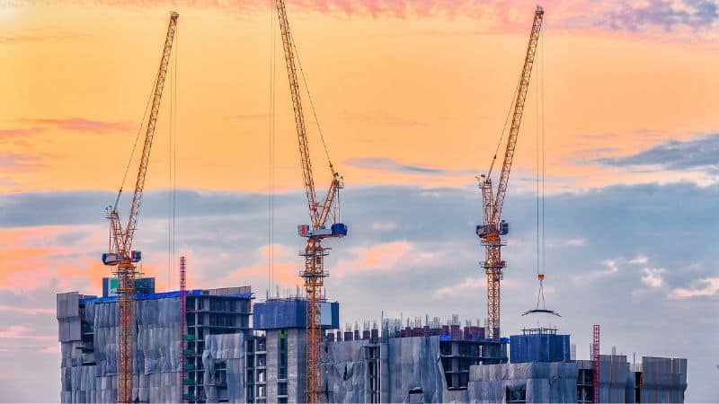 Image of cranes and construction work at sunset