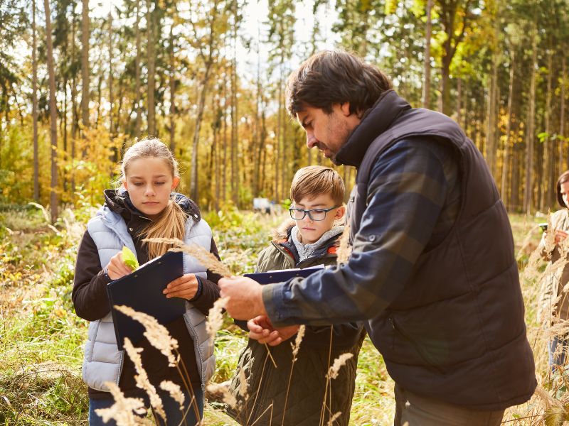 Environmental officer educating children in the woods