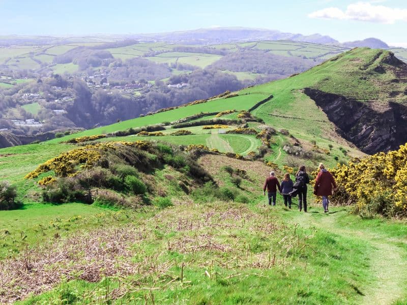 Four individuals walking in the hills in the UK countryside
