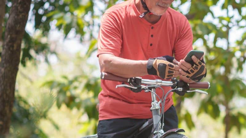 Man on a bike checking his phone