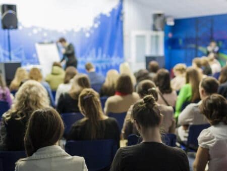 Photo of someone presenting on a stage in front of an audience