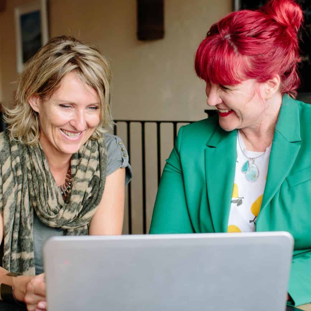 Photo of Traci Lewis and colleague working at a laptop