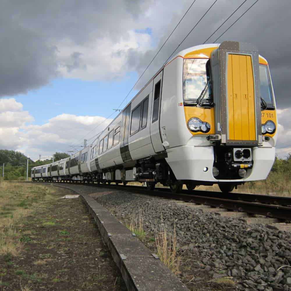 Photo of a train in motion, with a grey cloud above