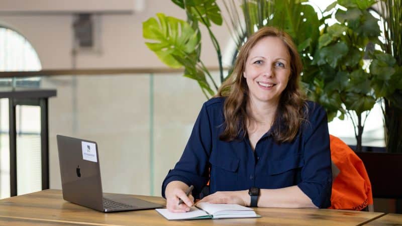 Photo of Emma Pye at a desk in front of her laptop