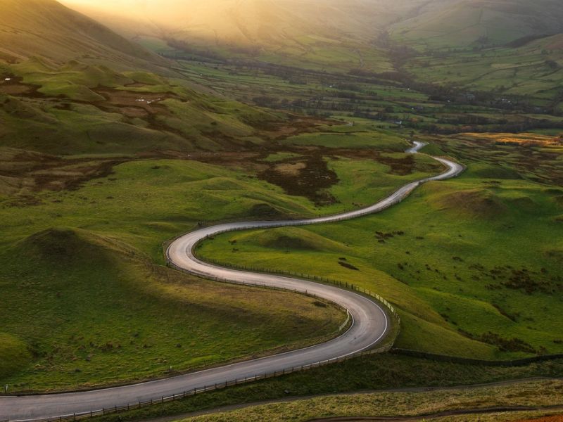 Photo of a rural scene with a winding road through it