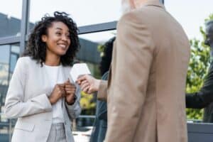 Photo of a woman being interviewed by somebody else, with a microphone being held in front of her