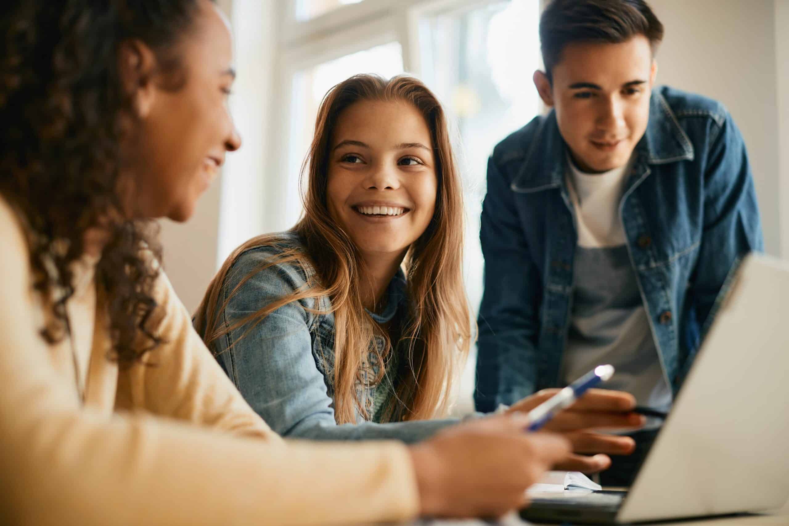 Teenagers looking at a screen and smiling