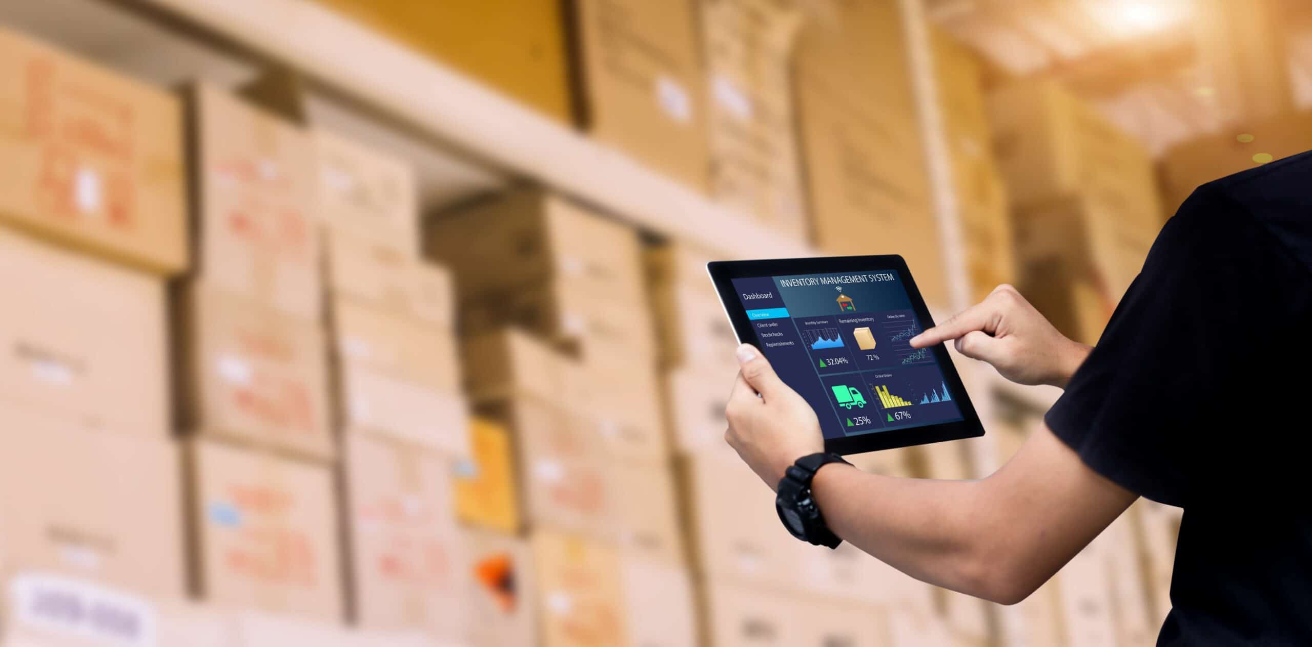 Person on a tablet in a warehouse, in front of lots of boxes