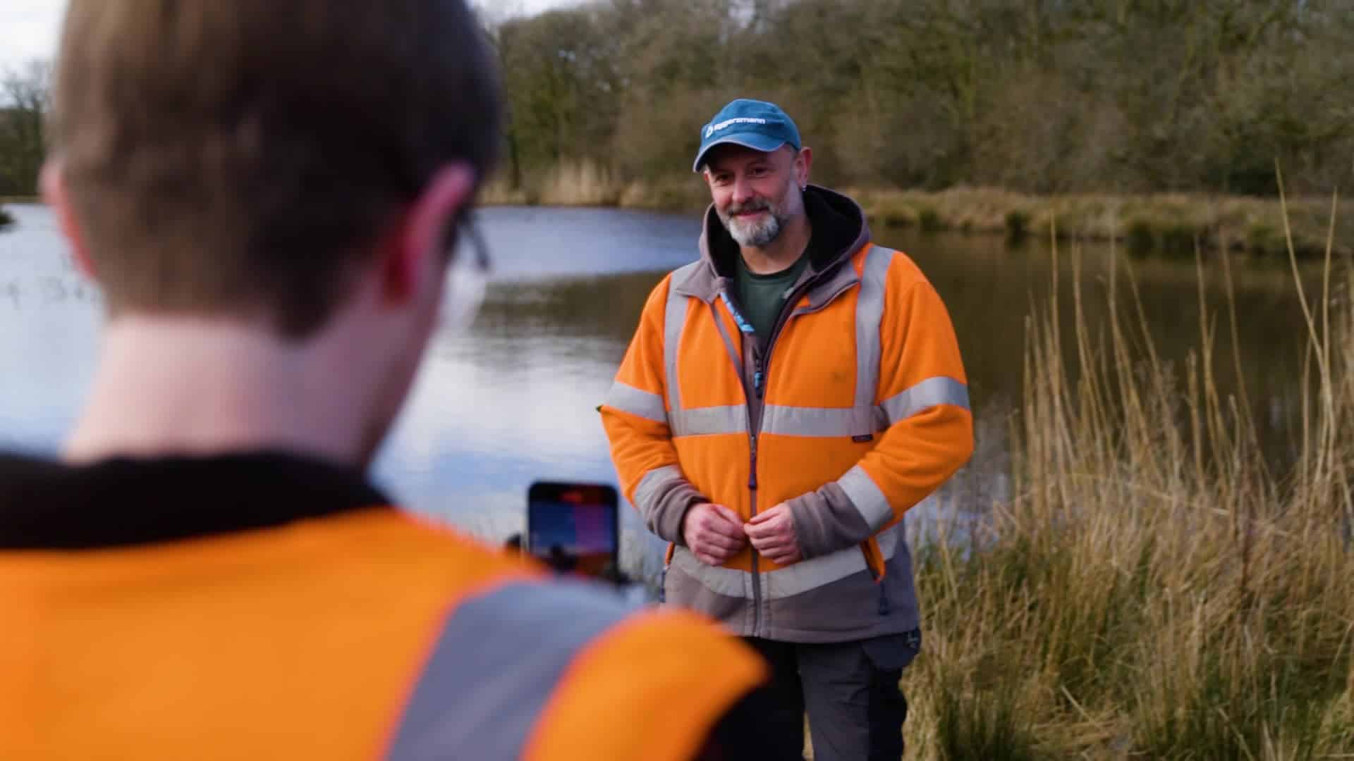 Photo of the filming at CWM - man talking to camera by a body of water