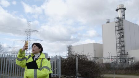 Person taking pictures of the surroundings with an industrial site in the background