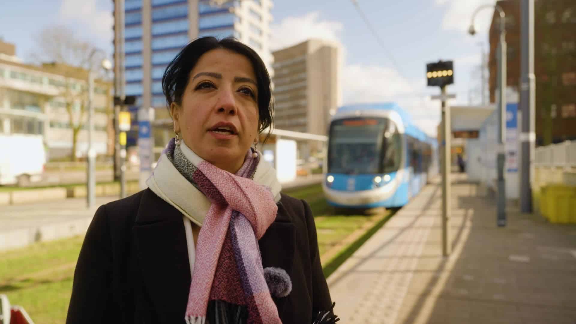 Person being interviewed with light rail vehicle in the background