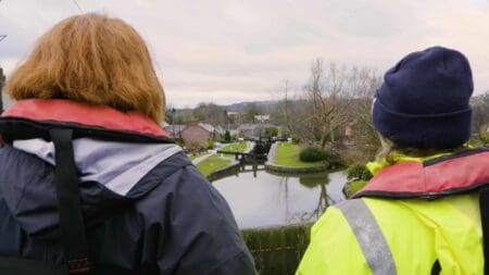 Two people looking at a canal in the background