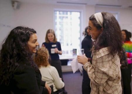 Two people of colour laughing in conversation