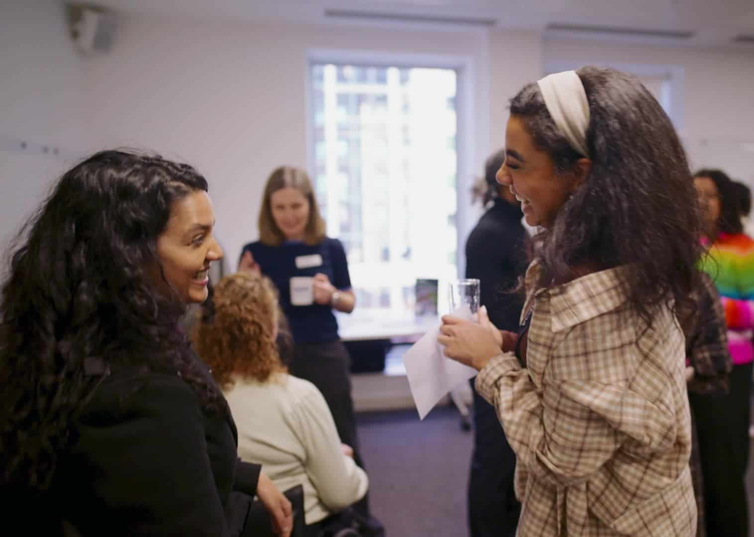 Two people of colour laughing in conversation