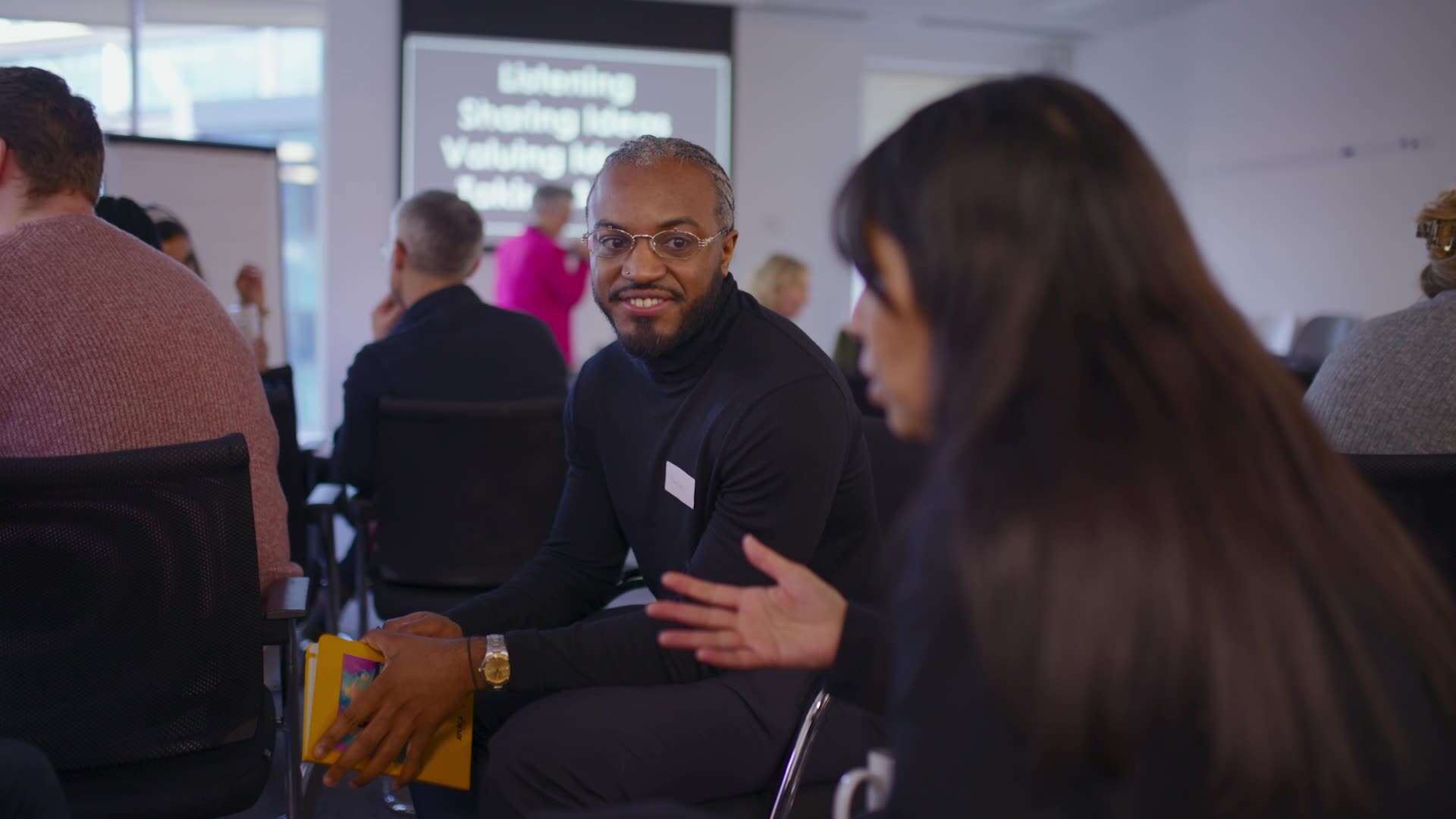 Two people of colour talking at an event