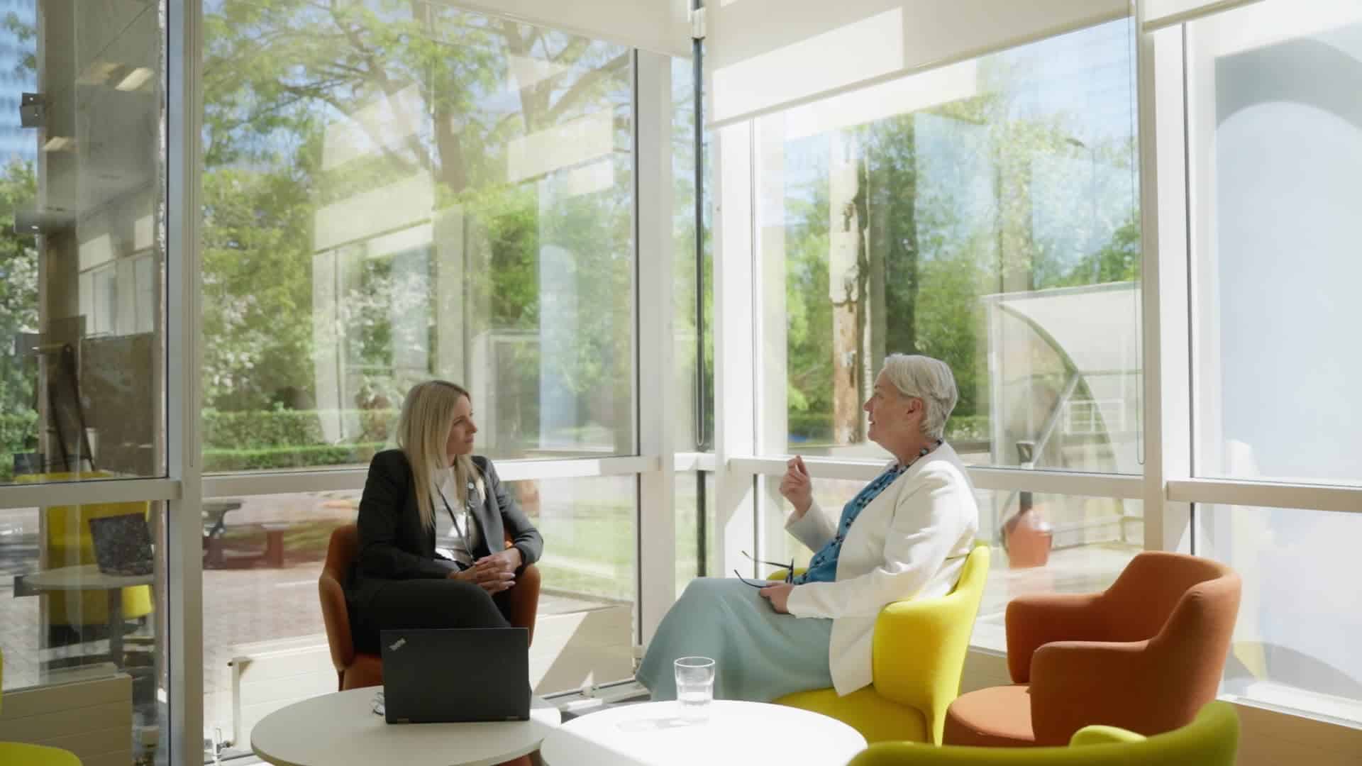 Two people sat chatting in a relaxed setting in an office environment