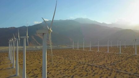 Photo of a wind turbine farm, in the sunshine
