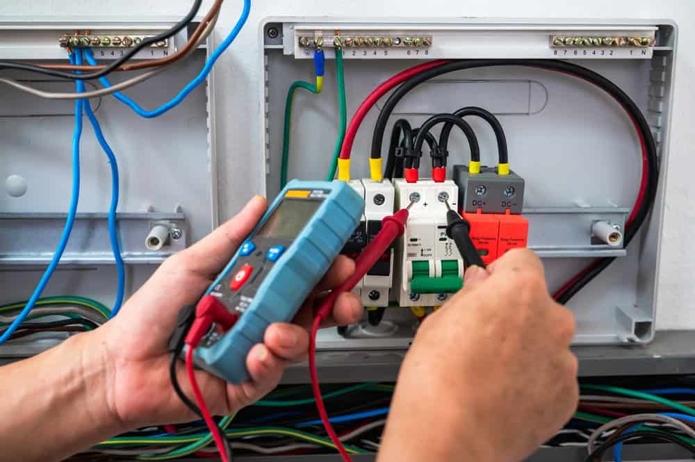 Up-close shot of somebody's hands working on an electrical point