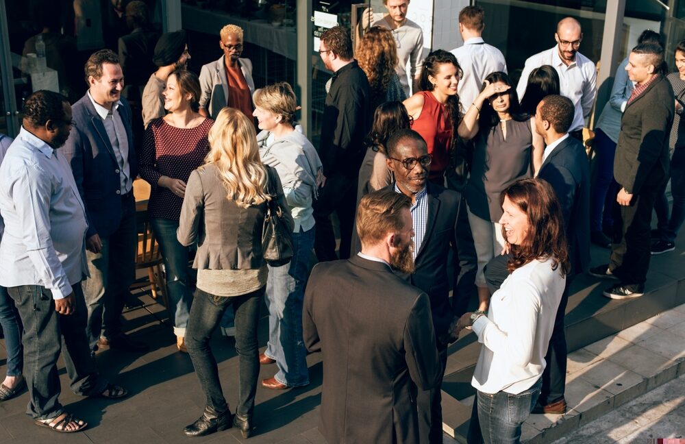 People stood outside in smaller groups talking to each other